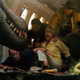 A dinosaur terrorizes the cast in a plane.